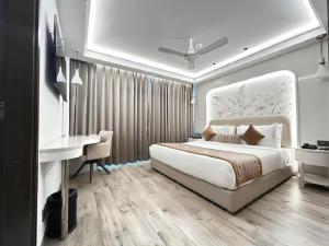 a bedroom with a white bed and a desk and a desk at Emerald Luxe A Boutique Hotel Chandigarh Mohali in Mohali