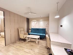 a living room with a blue couch and chairs at Emerald Luxe A Boutique Hotel Chandigarh Mohali in Mohali