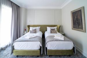 two beds sitting next to each other in a bedroom at VIZUALIZA Residence Hotel by HMG in Plovdiv