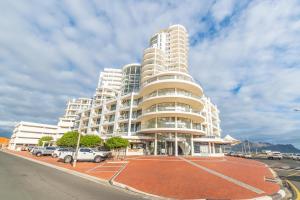 a tall white building with cars parked in a parking lot at Hibernian Towers 1503 in Strand
