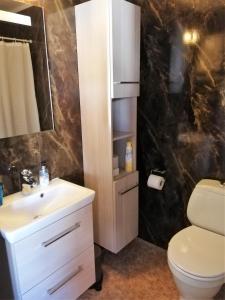 a bathroom with a white sink and a toilet at Løvheim Gjestehus in Sauland +45 photos