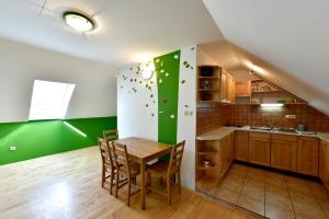 cocina con mesa y pared verde en Apartments Kozjanski park, en Podsreda