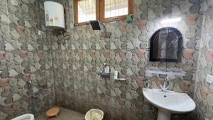 a bathroom with a sink and a stone wall at Dostel in Bhowāli