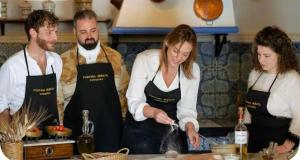 a group of people in a kitchen preparing food at Fontana Murata Resort & spa in Borgo Regalmici