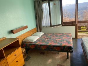 a bedroom with a bed and a window with a view at Duplex Superbe Vue Montagne in La Bourboule