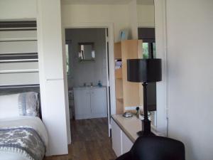 una camera da letto con un letto e una scrivania con una lampada di WILLOW BARN boutique B&B a Worle