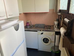 a small kitchen with a sink and a washing machine at Duplex Superbe Vue Montagne in La Bourboule