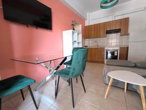 a living room with a glass table and green chairs at Johanna's apartment 2 in Preveza