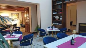 a restaurant with tables and blue chairs and bookshelves at Villa Alliata Relais & Spa in Palermo
