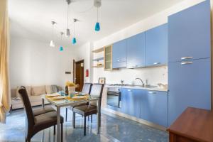 a kitchen with blue cabinets and a table and chairs at Borgagne Apartment by BarbarHouse in Borgagne