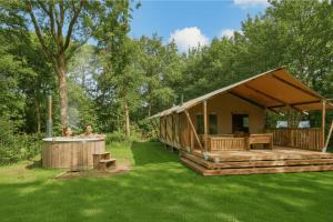 a house with a hot tub in the yard at Papillon Country Resort in Denekamp