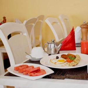 two plates of food on a table with eggs and fruit at Triple SSS Hotel in Nairobi
