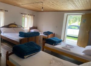ein Zimmer mit drei Betten mit blauen Kissen darauf in der Unterkunft The Eagle in Hardedaj