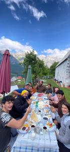 Eine Gruppe von Menschen sitzt an einem langen Tisch und isst. in der Unterkunft The Eagle in Hardedaj + 1 Foto