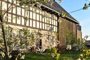 an exterior view of a building with flowers in the yard at Noclegi i chleb in Kłopotnica