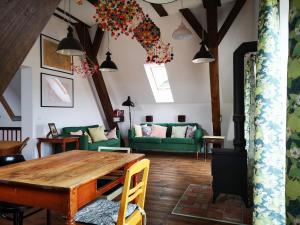 a living room with a table and a green couch at Noclegi i chleb in Kłopotnica