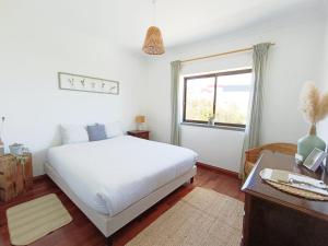 a bedroom with a white bed and a window at Villa Intuitiva - Relaxation and Mindful Stay in Lourinhã