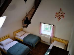 two beds in a small room with a window at Noclegi i chleb in Kłopotnica