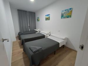 a room with three beds in a room at Apartamentos Illa Pancha in Ribadeo