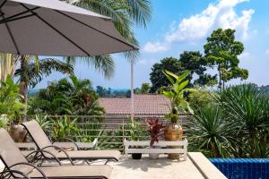 a patio with chairs and an umbrella and a pool at Chaweng Boho Modern in Ban Ko Khwan