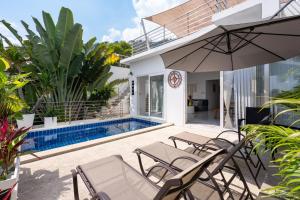 a patio with chairs and an umbrella next to a swimming pool at Chaweng Boho Modern in Ban Ko Khwan