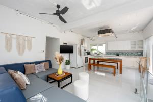 a living room with a blue couch and a kitchen at Chaweng Boho Modern in Ban Ko Khwan