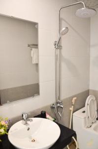 a bathroom with a sink and a toilet and a mirror at Song Kieu Hotel - Self check-in in Ha Long +52 photos