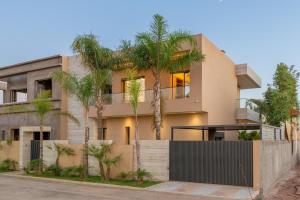 a house with palm trees in front of it at Villa Capella heated pool and cooker in Marrakesh