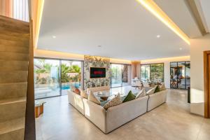 an open living room with couches and a tv at Villa Capella heated pool and cooker in Marrakesh