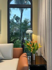 a living room with a couch and a window with a palm tree at V3K05A Sonasea Vân Đồn in Quang Ninh