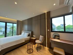 a bedroom with a bed and a chair and windows at V3K05A Sonasea Vân Đồn in Quang Ninh
