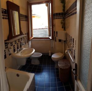 a bathroom with two toilets and a sink and a tub at Casa Belvedere in Manarola