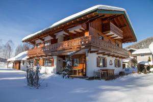 a large wooden house in the snow at Ferienwohnung Haus Rieder Inzell in Inzell