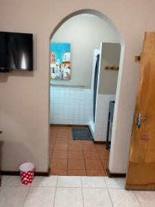 a bathroom with an open door and a tile floor at Marzel Guesthouse - Room 2 in Britstown