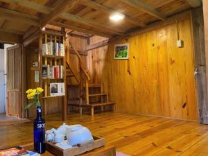 a room with wooden floors and a book shelf and a vase at Đà Lạt Củi Homestay in Da Lat