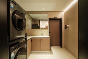 a small kitchen with a sink and a microwave at Panda Sleepy Hotel（Chengdu Panda Base) in Chengdu