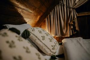 a close up of a bed with pillows on it at Na Gorczańskim Wierchu Chalet, basen, sauna, balia na wyłączność in Rabka-Zdrój