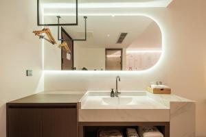 a bathroom with a sink and a mirror at Panda Sleepy Hotel（Chengdu Panda Base) in Chengdu +123 photos