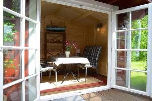 a porch of a cabin with a table and chairs at Ferienwohnung in Oevenum auf Foehr in Oevenum