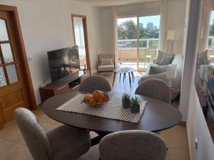 a living room with a table and chairs and a television at Rio Nacimiento in Campoamor