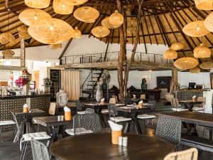 a restaurant with tables and chairs and chandeliers at Biu Biu Resort Bali in Jimbaran