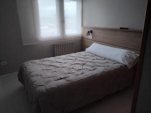 a bedroom with a white bed with a window at Ruta Esmeralda in Baamonde
