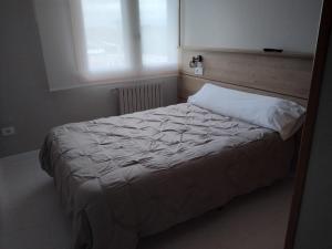 a bedroom with a white bed with a window at Ruta Esmeralda in Baamonde