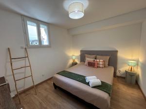 a bedroom with a bed with two towels on it at Appartement Ajaccio T3 in Ajaccio