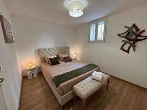 a bedroom with a large bed and a bench at Appartement Ajaccio T3 in Ajaccio