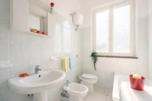 a white bathroom with a sink and a toilet at Terrazza Verdi-Roseto Vacanza in Roseto degli Abruzzi +2 photos