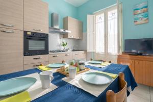a kitchen with a table with blue plates on it at Terrazza Verdi-Roseto Vacanza in Roseto degli Abruzzi