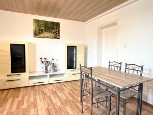 a dining room with a wooden table and chairs at Asia Oase in Arendsee +14 photos