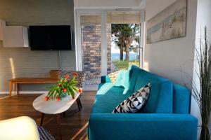 a blue couch in a living room with a table at Apartament Vespa in Mechelinki