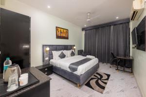 a hotel room with a bed and a desk at La Comfort By shrpl in Gurgaon +17 photos
